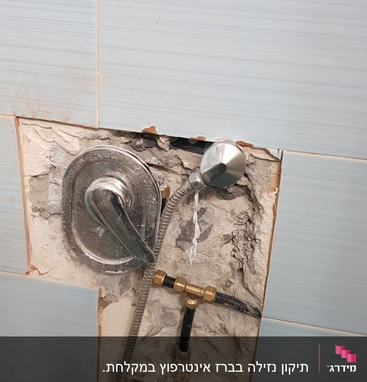 ברז מקלחת חשוף עם צינור מתכת בקיר פתוח